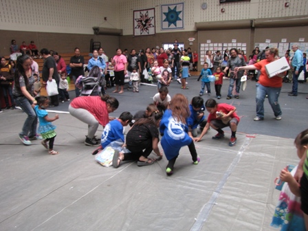 People doing an Earth Day project on the floor of a gym