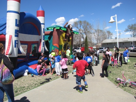 Kids and adults in front of bouncy houses